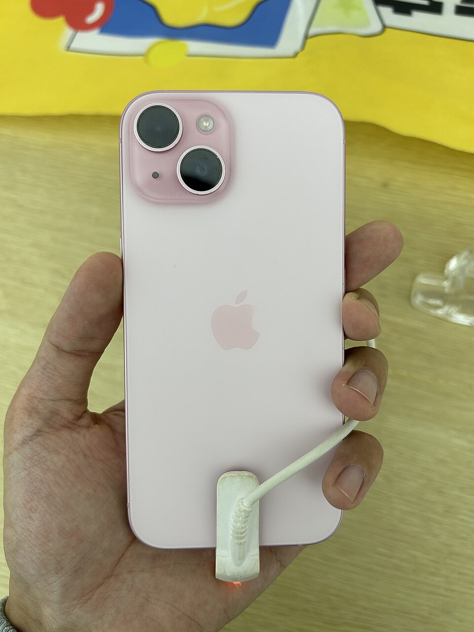iPhone 15 rose, vue arrière — photo illustrative du modèle, non de l’appareil livré.